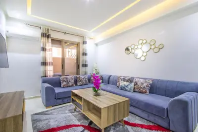 a living room with a blue couch and a table at Relax, Modern, Centre Gueliz in Marrakech