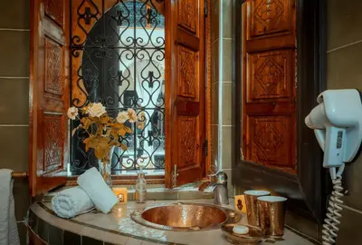 a bathroom with a sink with a phone and a window at Riad Rodaina & SPA in Marrakech