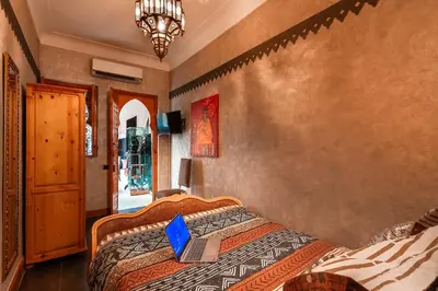 a bedroom with a bed with a laptop on it at Riad Rodaina & SPA in Marrakech