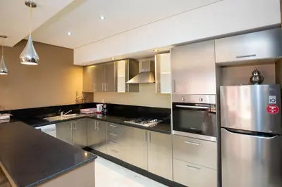 a kitchen with stainless steel appliances and black counter tops at studio design carre eden gueliz IPTV , NETFLIX , WIFI, in Marrakech