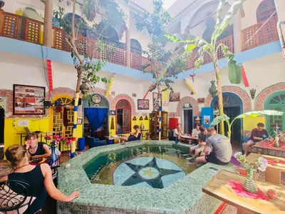 a group of people sitting around a pool in a building at Riad Dia in Marrakech