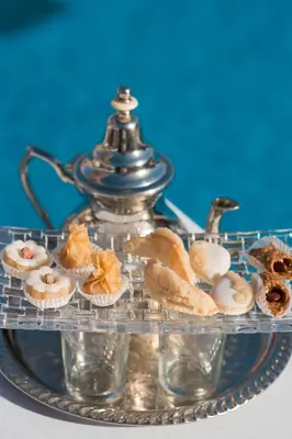 a tray of pastries and a tea kettle on a table at Grand Mogador Agdal & Spa in Marrakech