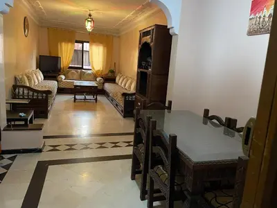 a living room with a table and a couch at Appartement dans résidence avec piscine in Marrakech