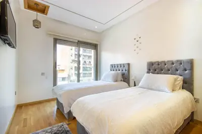 a bedroom with two beds and a large window at NEW! Appartement de luxe emplacement idéal Gueliz in Marrakech