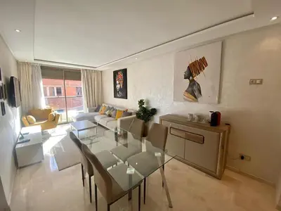 a living room with a glass table and a couch at APPARTEMENT CARRE EDEN in Marrakech