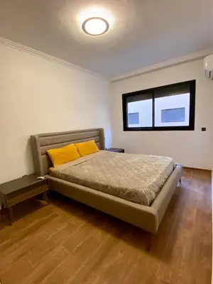 a bedroom with a bed with yellow pillows and a window at Appartement 2 chambres salon centre de Gueliz 19 in Marrakech