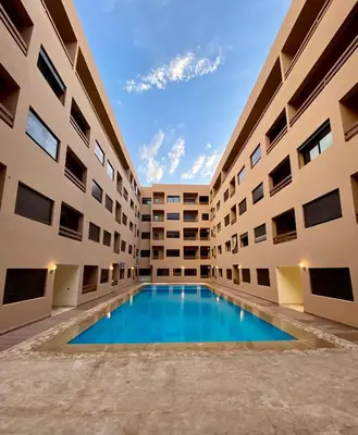 an empty courtyard of an apartment building with a swimming pool at Appartement 2 chambres salon centre de Gueliz 19 in Marrakech