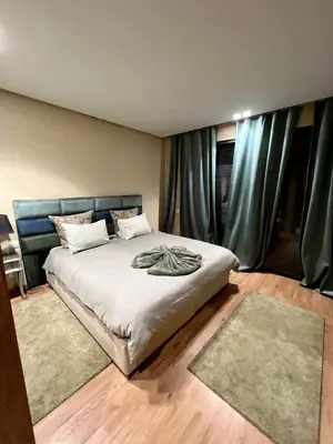 a bedroom with a large bed with green curtains at Appartement 2 chambres salon a cote centre de Gueliz 12 in Marrakech