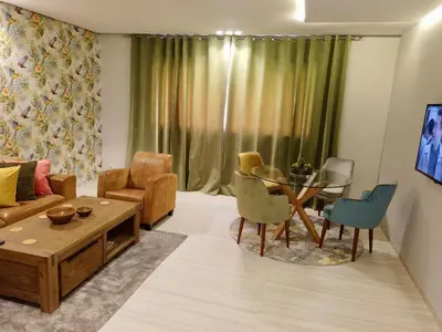 a living room with a couch and a table and chairs at Appartement 2 chambres salon a cote centre de Gueliz 12 in Marrakech
