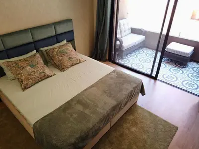 a bedroom with a bed with a mirror and a chair at Appartement 2 chambres salon a cote centre de Gueliz 12 in Marrakech