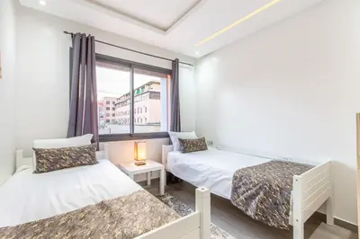 a small room with two beds and a window at New! Appartemant au millieu de guéliz in Marrakech
