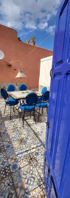 a blue door with chairs and a table in front of a building at Maison 211 in Marrakech