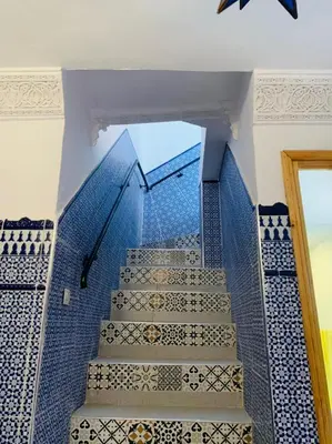 a set of stairs with blue tiles and a mirror at Maison 211 in Marrakech