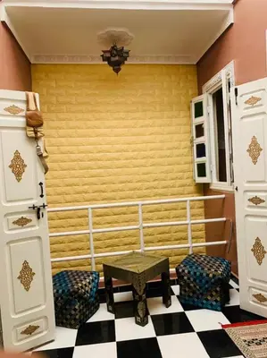 a room with two chairs and a table and a yellow wall at Maison 211 in Marrakech