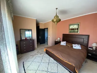 a bedroom with a large bed and a chandelier at atlas golf resort marrakech 