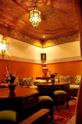 a living room with a couch and tables and a ceiling at Riad La Perle de Marrakech in Marrakech
