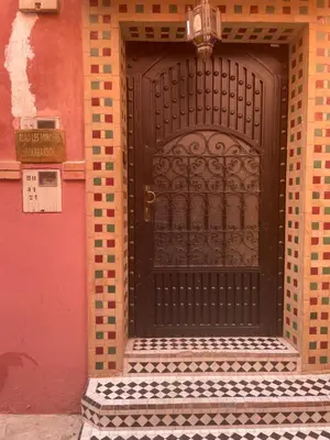 a black door on a building with a sign on it at Riad Les Miroirs in Marrakech