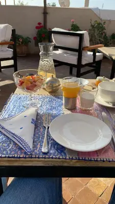 a table with a plate of food on top of it at Riad Al Massarah in Marrakech