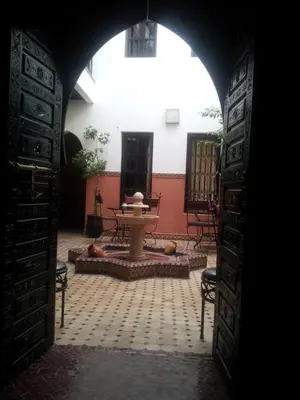 an archway leading into a courtyard with a table and chairs at RIAD Le MINASDAM in Marrakech