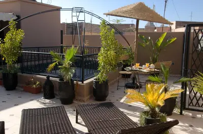a patio with tables and chairs and potted plants at RIAD Le MINASDAM in Marrakech