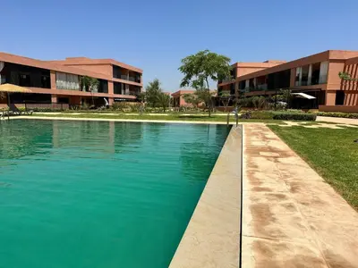 a swimming pool in front of a building at LDM Appartements Marrakech in Marrakech