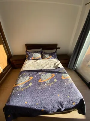 a bed with a blue comforter and pillows at Best Appartement 3 BEDROOMS in Marrakech