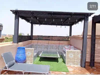 a pergola with a table and chairs on a patio at Chez balqis atlas golf in Marrakech