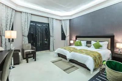 a bedroom with a bed and a desk and a chair at The BIRD in Marrakech