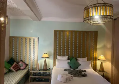 a bedroom with a large bed and a chandelier at Riad Dar Fanny in Marrakech