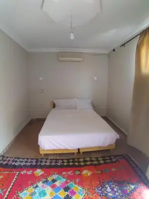 a bedroom with a white bed and a rug at Riad 9 Derb El Bousnne in Marrakech