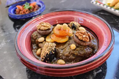 a red bowl of food with nuts and other foods at Majorel Perle Hôtel Riad Restaurant Picine & Spa in Marrakech