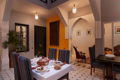 a dining room with a table and chairs at Riad Mylaya in Marrakech