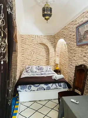 a bedroom with a bed in a brick wall at Archduke private rooms in Marrakech