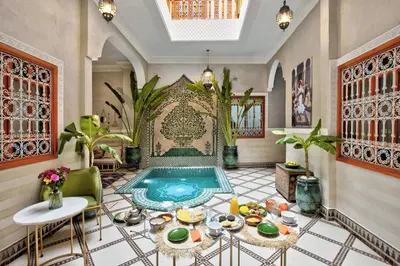a living room with a pool in the middle of the room at Riad Arabkech in Marrakech
