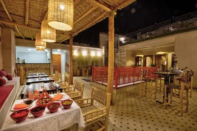 a restaurant with tables and chairs in a room at Riad Arabkech in Marrakech
