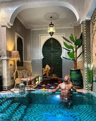 a man swimming in a swimming pool in a house at Riad Arabkech in Marrakech
