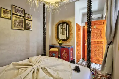 a room with a bed and a mirror on the wall at Riad Arabkech in Marrakech