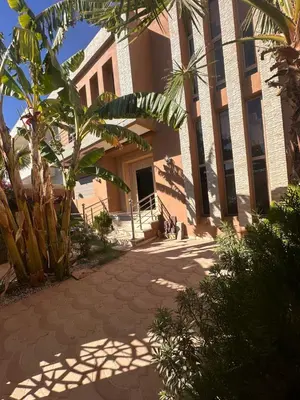 a building with a palm tree in front of it at villa with private pool only family in Marrakech