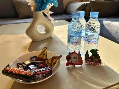 a table with two bottles of water and a plate of snacks at Appartement Marrakech avec piscine in Marrakech