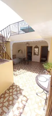 a patio with a table and chairs in a building at Riad chaoui house in Marrakech