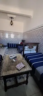 a room with two beds and a table in it at Riad chaoui house in Marrakech