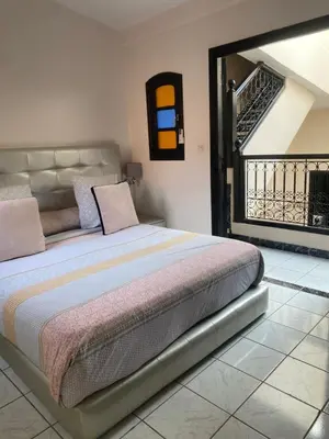 a bedroom with a bed in a room with a staircase at Riad Lyna in Marrakech