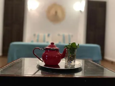 a red tea pot and a glass cup on a table at Riad Laksiba in Marrakech