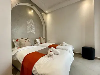 a room with three beds with shoes on them at Riad Al Hamama in Marrakech