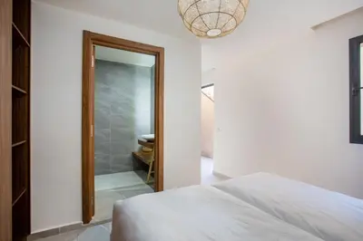 a bedroom with a bed and a mirror at Villa Nounja Golf Amelkis Marrakech in Marrakech