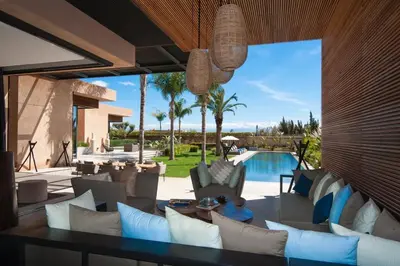 a living room with couches and a swimming pool at Villa Dar Balou - FAMILY ONLY in Marrakech