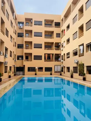 an apartment building with a large swimming pool at Luxury Apartment in the center of Gueliz Marrakech in Marrakech