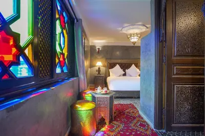 a room with a bed and a stained glass window at Riad Mazaj in Marrakech