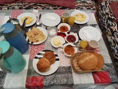 a table with plates of breakfast food on it at Riad taddert in Marrakech
