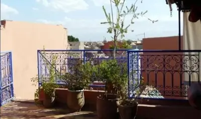 a balcony with potted plants and a blue fence at Riad taddert in Marrakech